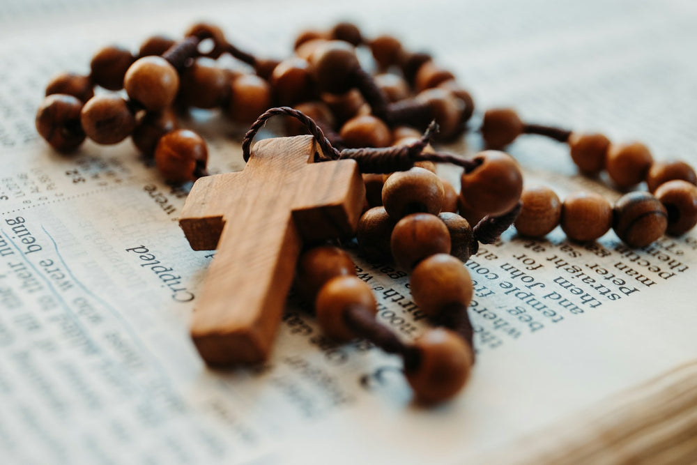 Placeholder close-up photograph of a wooden rosary cross. Photo by James Coleman on Unsplash; not an actual Blessed By Mary product.